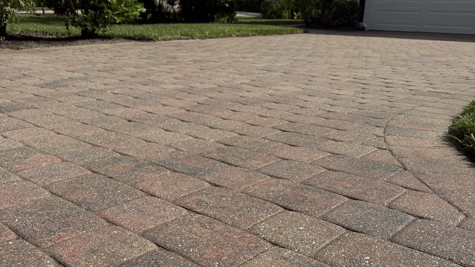 A washed paver driveway in Naples with a curved border course