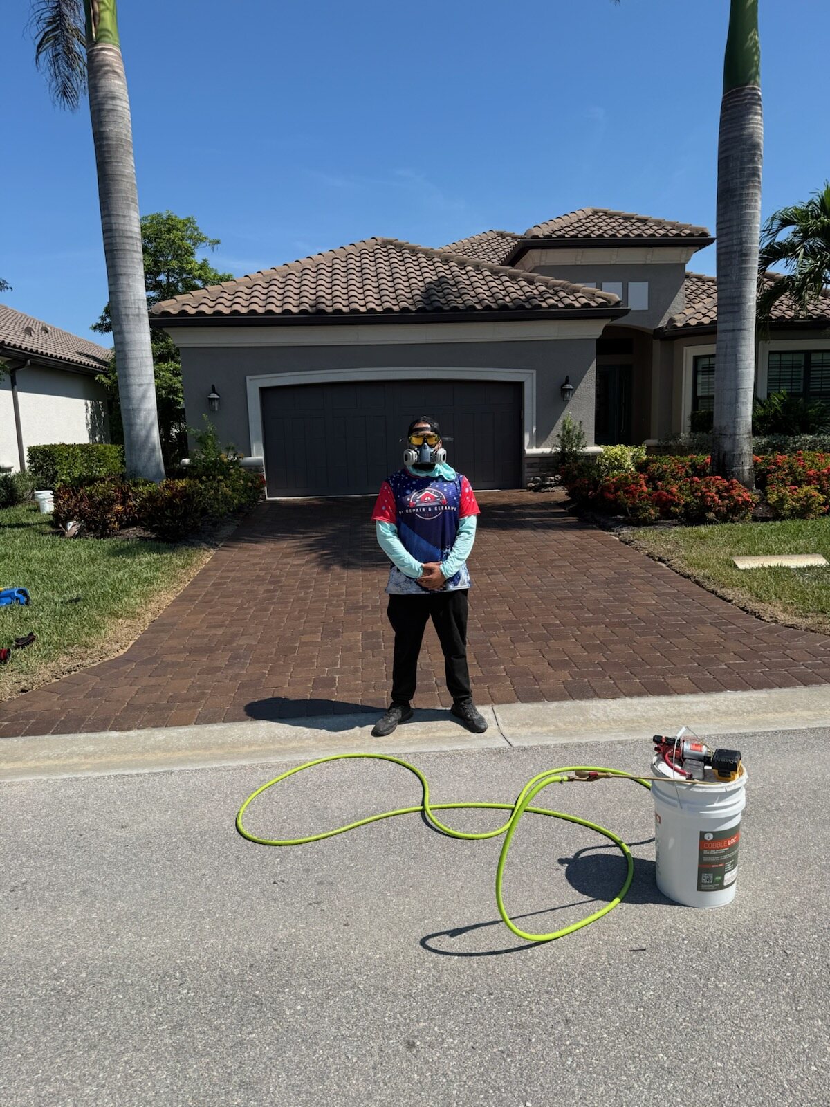 Cristian in his respirator on a freshly sealed paver driveway in Naples
