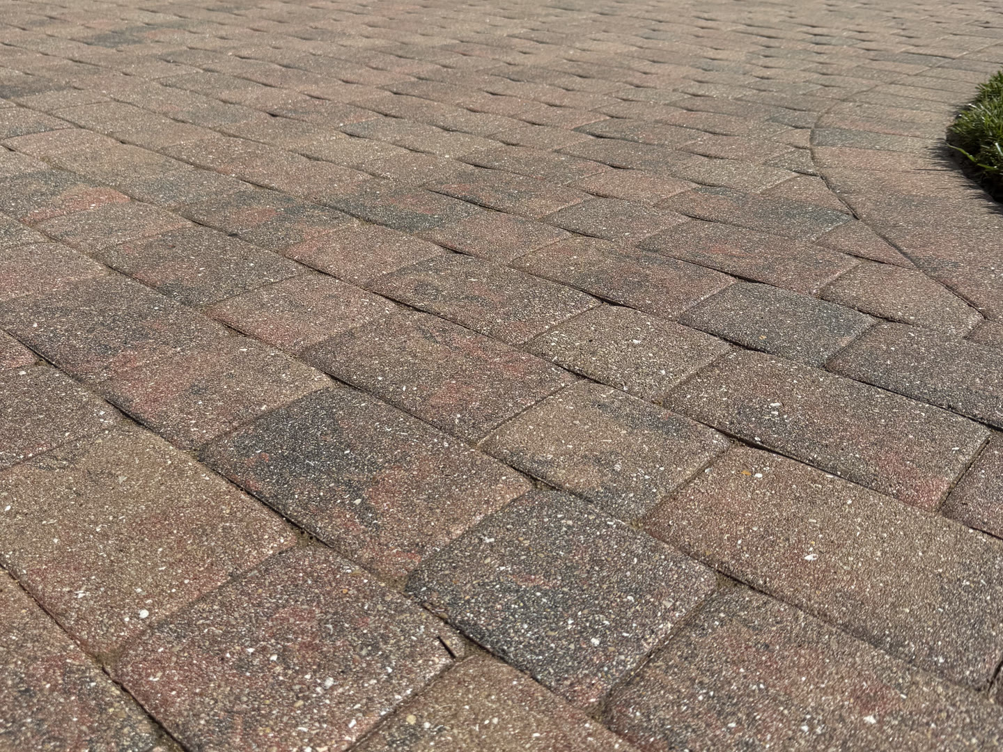 Red and charcoal pavers on a Naples driveway with the color back in them