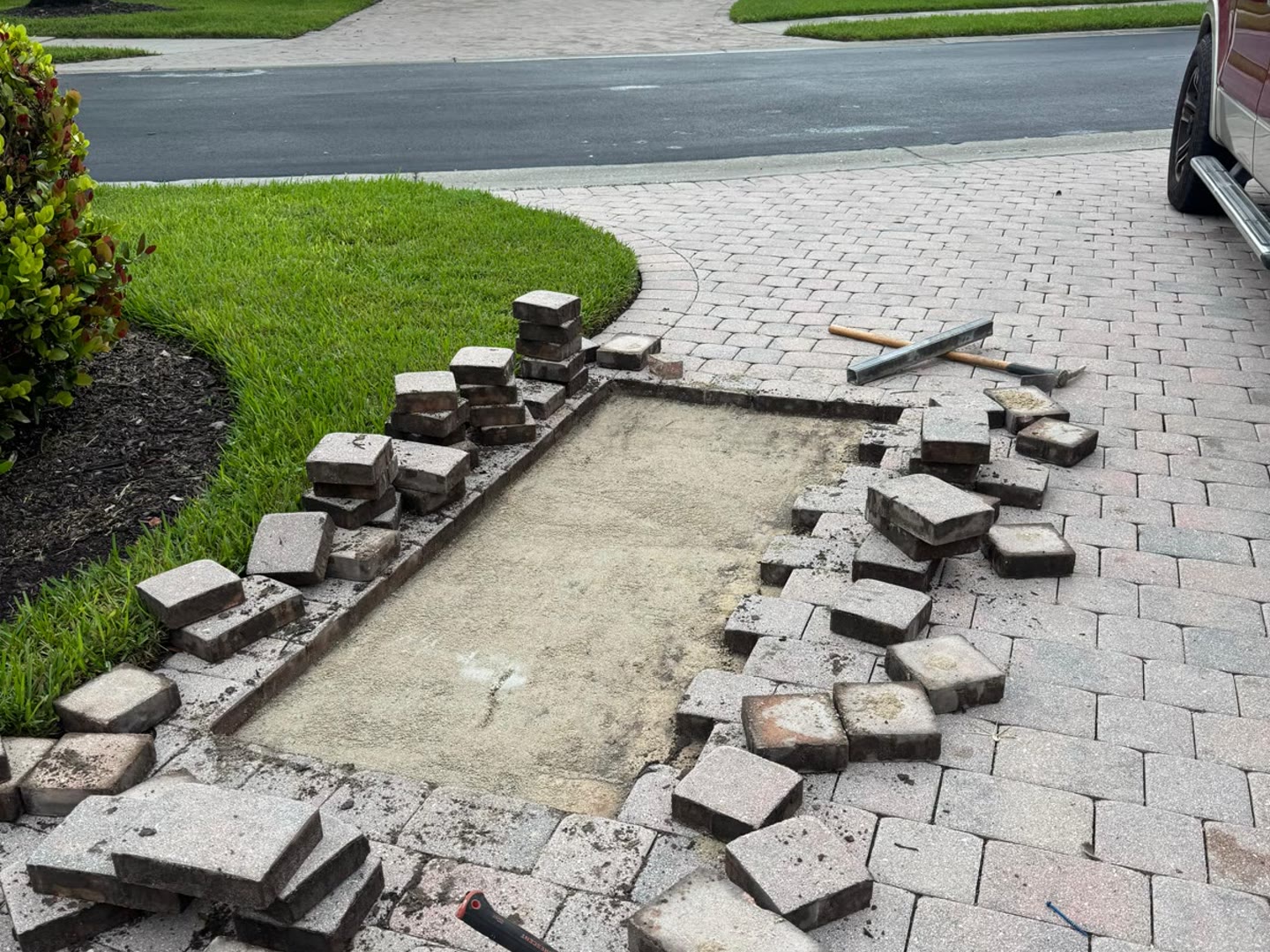 The same driveway with the pavers lifted and stacked clear of the work area
