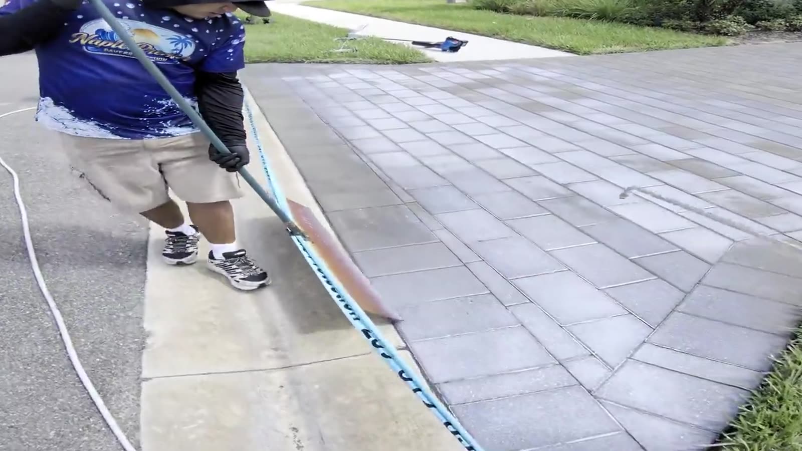 Joint sand being worked into a paver driveway in Naples with a broom